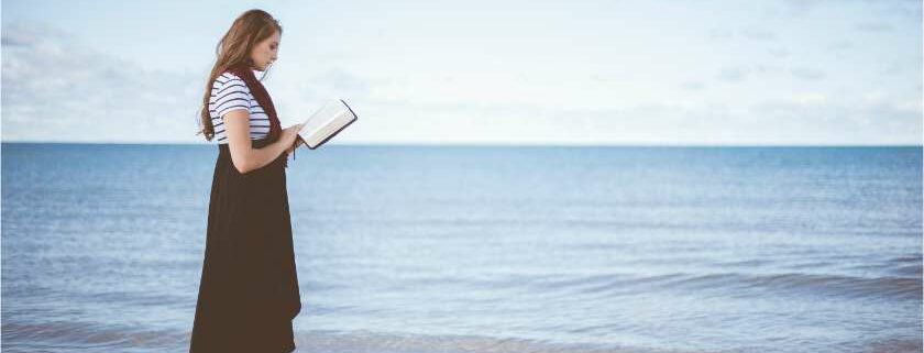 woman holding bible on beach and 22222 meaning bible