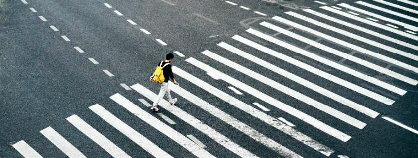 person crossing on pedestrian lane and walking with god