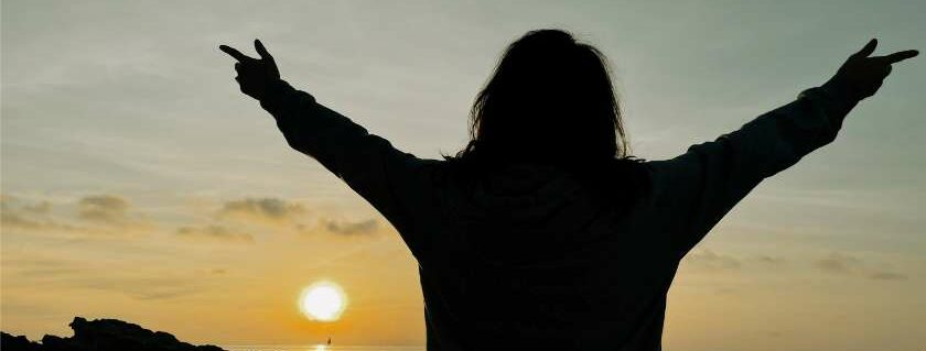 silhouette of a woman raising hands and glory to god bible verse