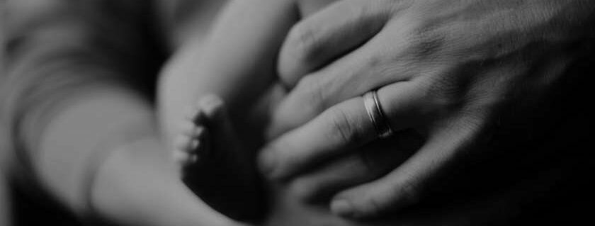 dad father holding baby feet