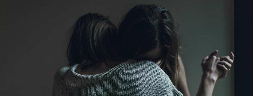 two women dance hug and comfort each other