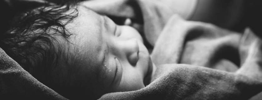 black and white photo of newborn baby wrapped in cloth