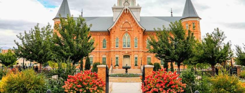 orange and gray mormon building with gate and garden in front and do mormons believe in jesus