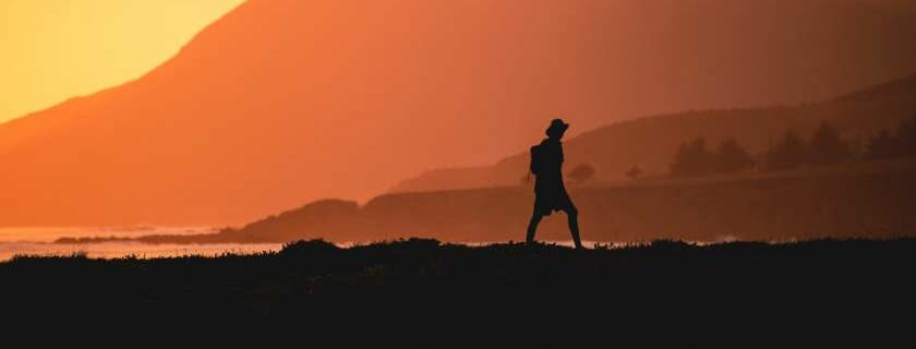 silhouette of a man walking during sunset across mountains and satan tempts jesus