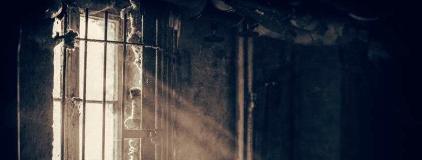 sunlight streaming through barred windows in abandoned building